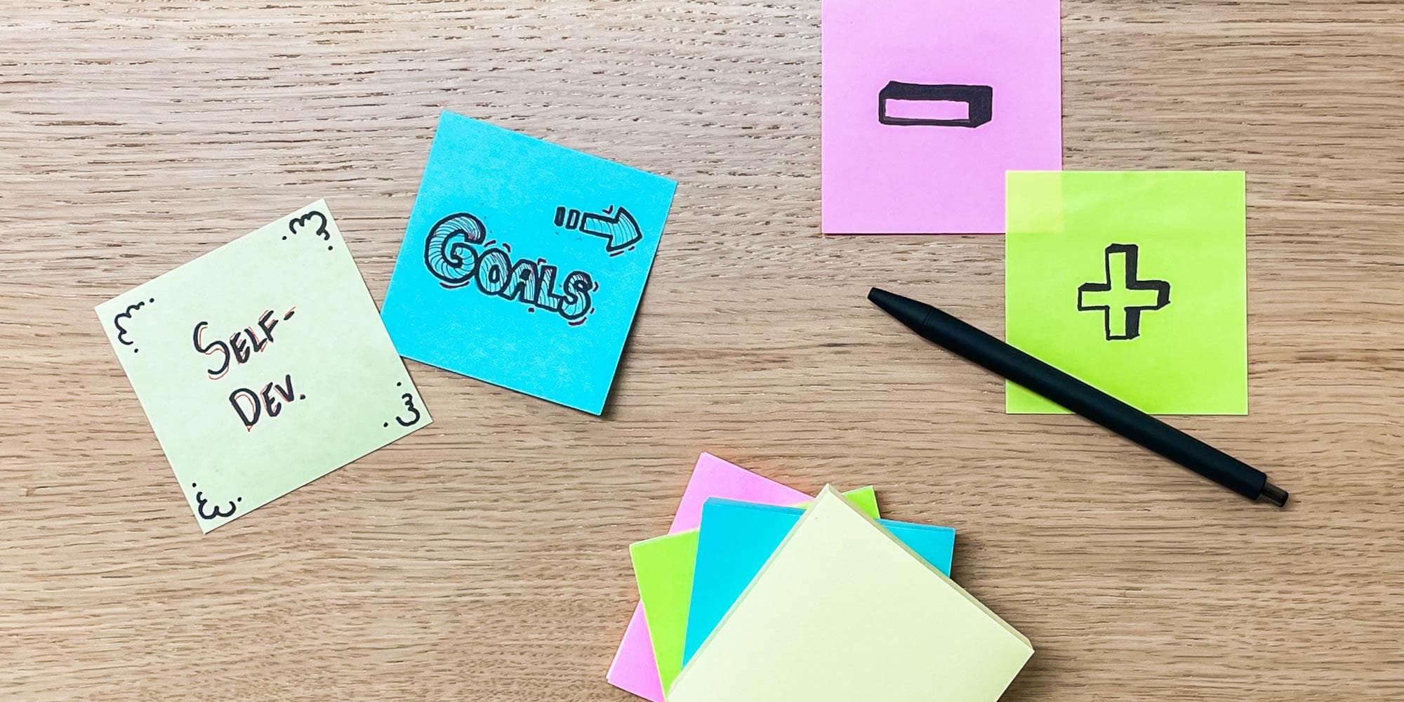 Post it lappuja, joissa on mainittu mm. urakehitys ja tavoitteet sekä laput, joissa on plus- ja miinusmerkit