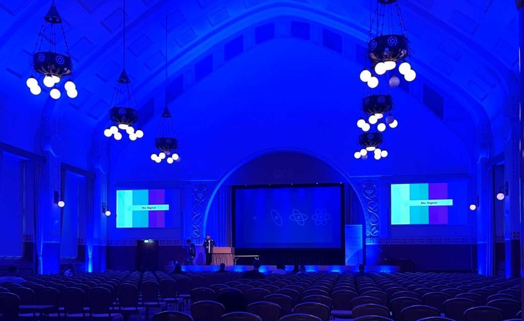 An image of the main hall at React Finland 2022 conference with a stage and empty seats 